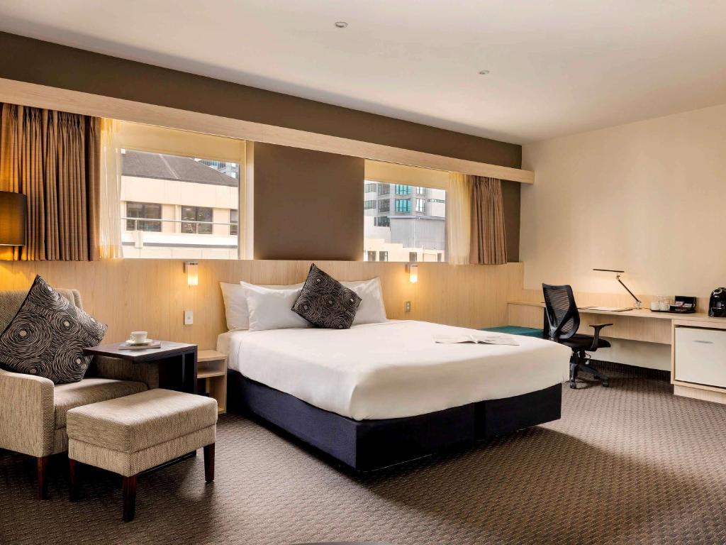 a hotel room with a large bed and a desk at ibis Wellington in Wellington