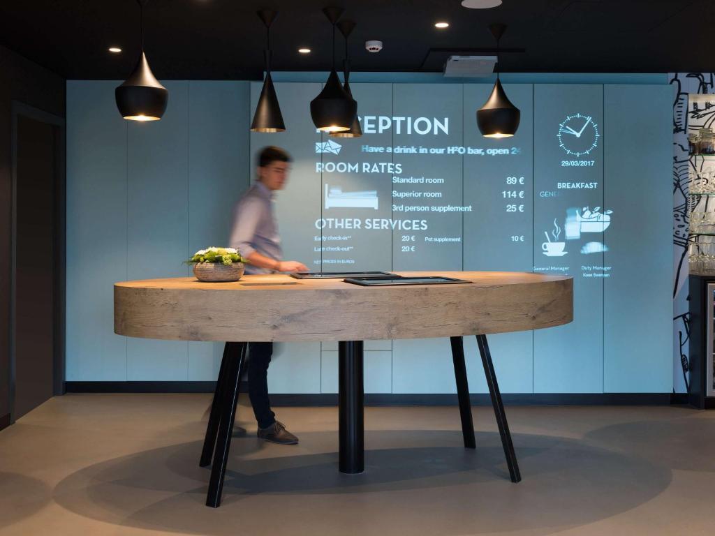 a man standing in front of a table at ibis Aalst in Aalst