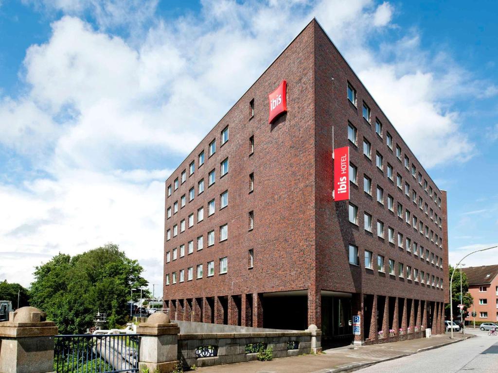 a red brick building with a sign on the side of it at ibis Hamburg Alsterring in Hamburg