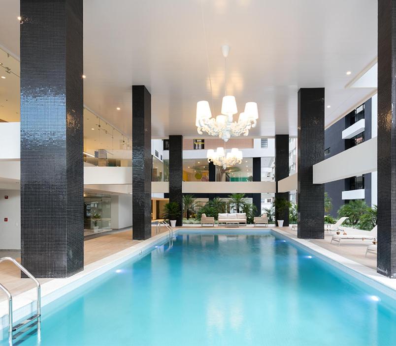 a large swimming pool in a building with a chandelier at 1440 Lujuso Departamento en Quito - La Recoleta in Quito