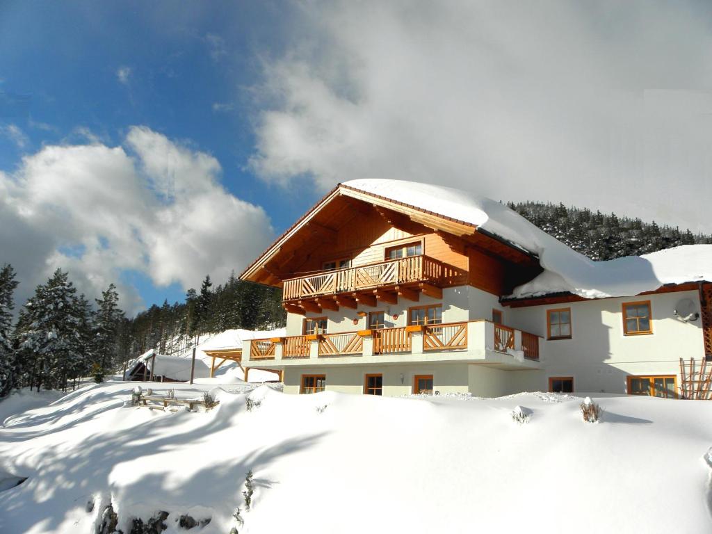 een gebouw met sneeuw op de grond ervoor bij Appartements Hochegg in Schladming