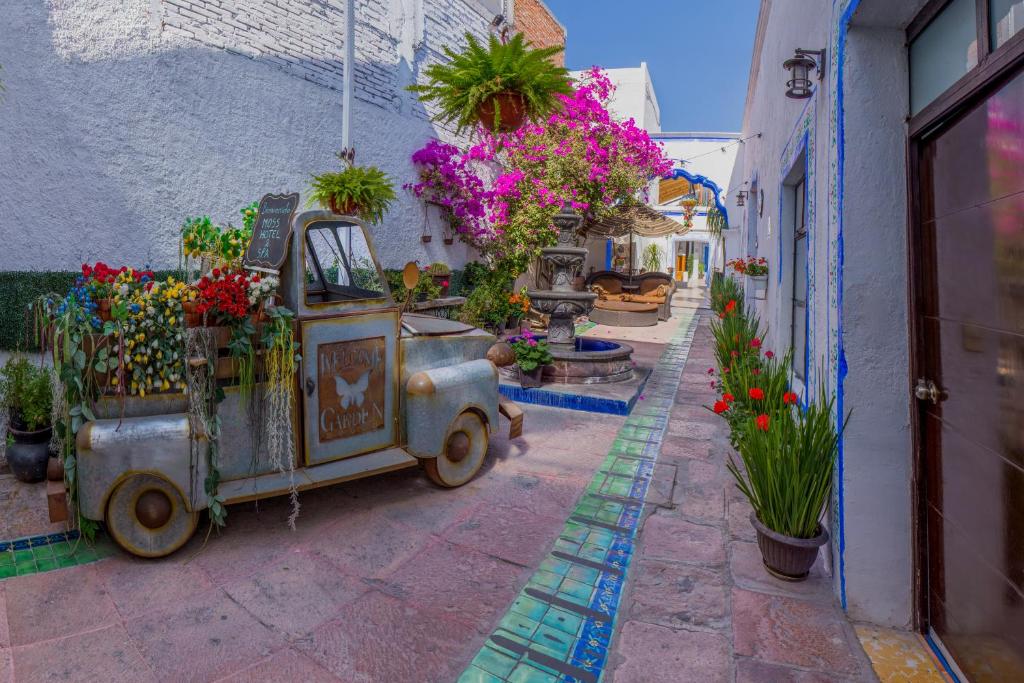 an old car parked next to a building with flowers at Hotel & Spa La Mansion del B Azul in Querétaro