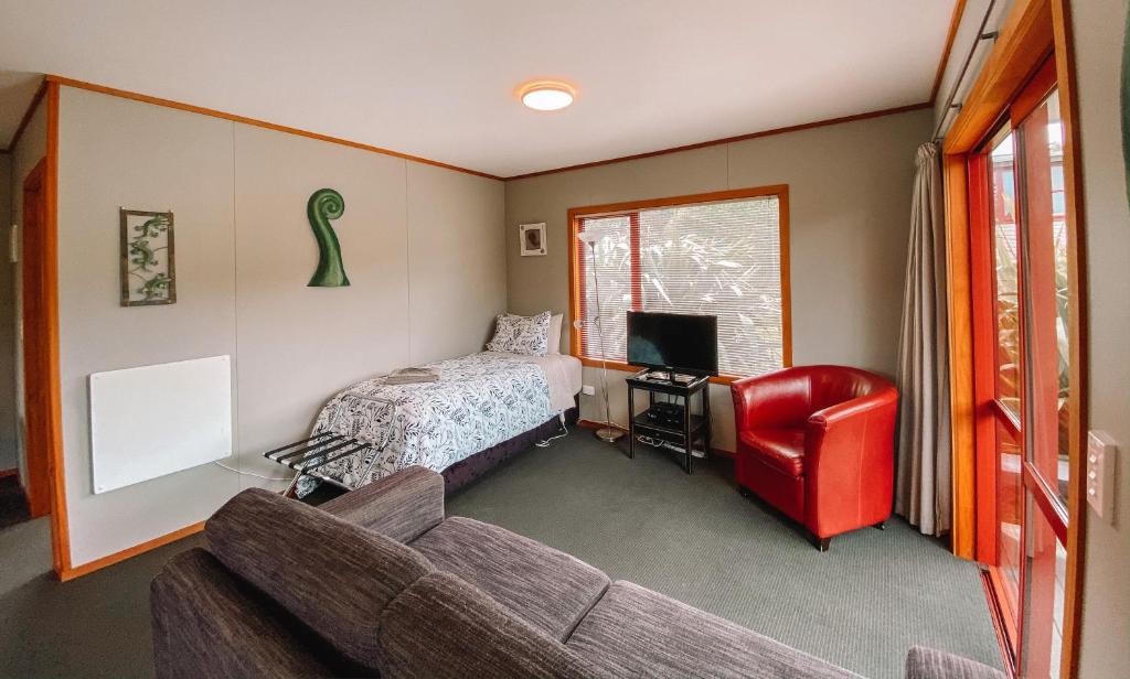 un soggiorno con divano e letto di The Whistling Frog Resort a Chaslands
