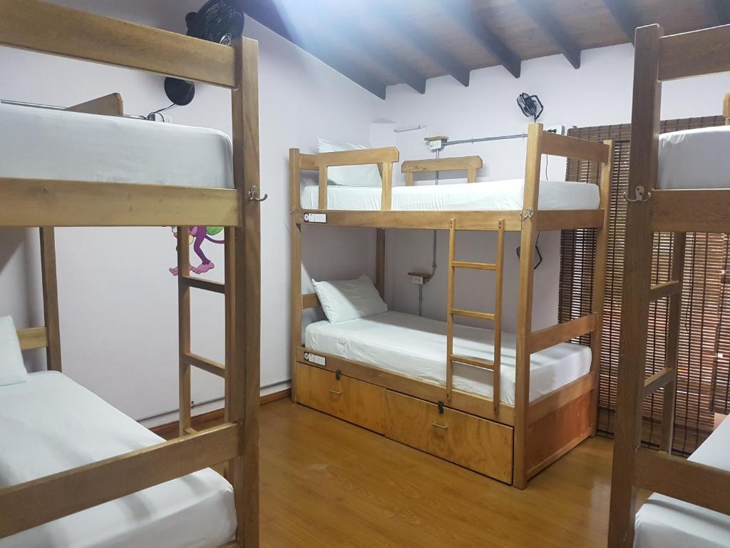 a room with three bunk beds in a room at Purple Monkey Hostel in Medellín