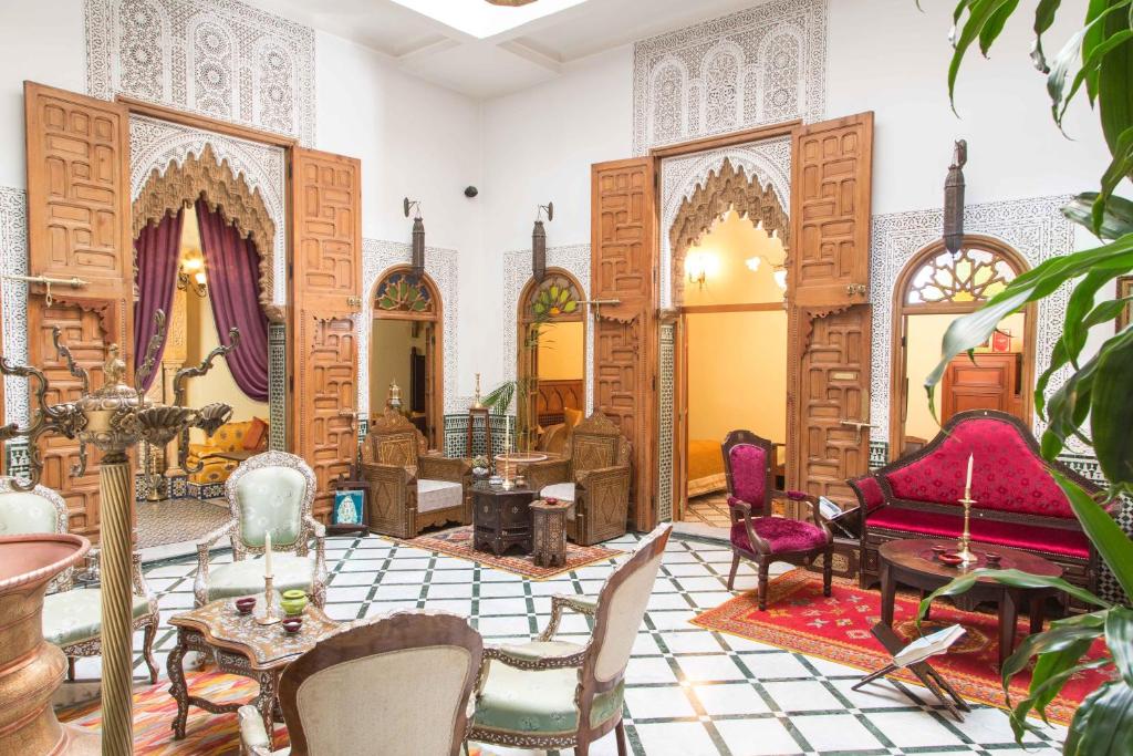 uma sala de estar com cadeiras e uma mesa em Dar El Kébira em Rabat