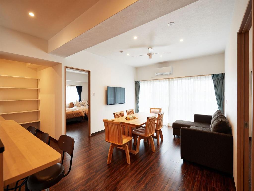 北谷町的住宿－M´s Stay Okinawa，客厅配有桌子和沙发