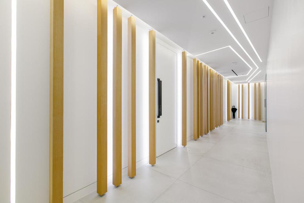 a hallway in an office building with white walls and yellow columns at Nsplace in Athens