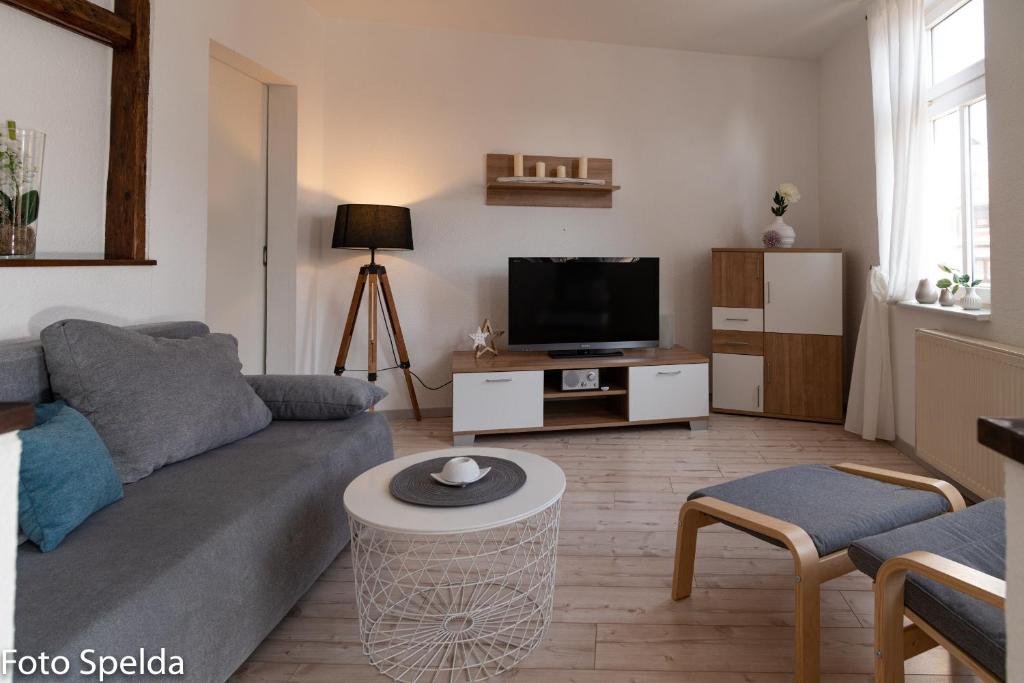 een woonkamer met een bank en een tv bij Tom´s Ferienappartements in Tabarz