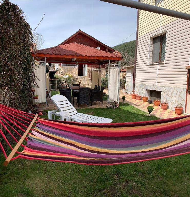 a hammock in a yard next to a house at Sunny House in Madzhare