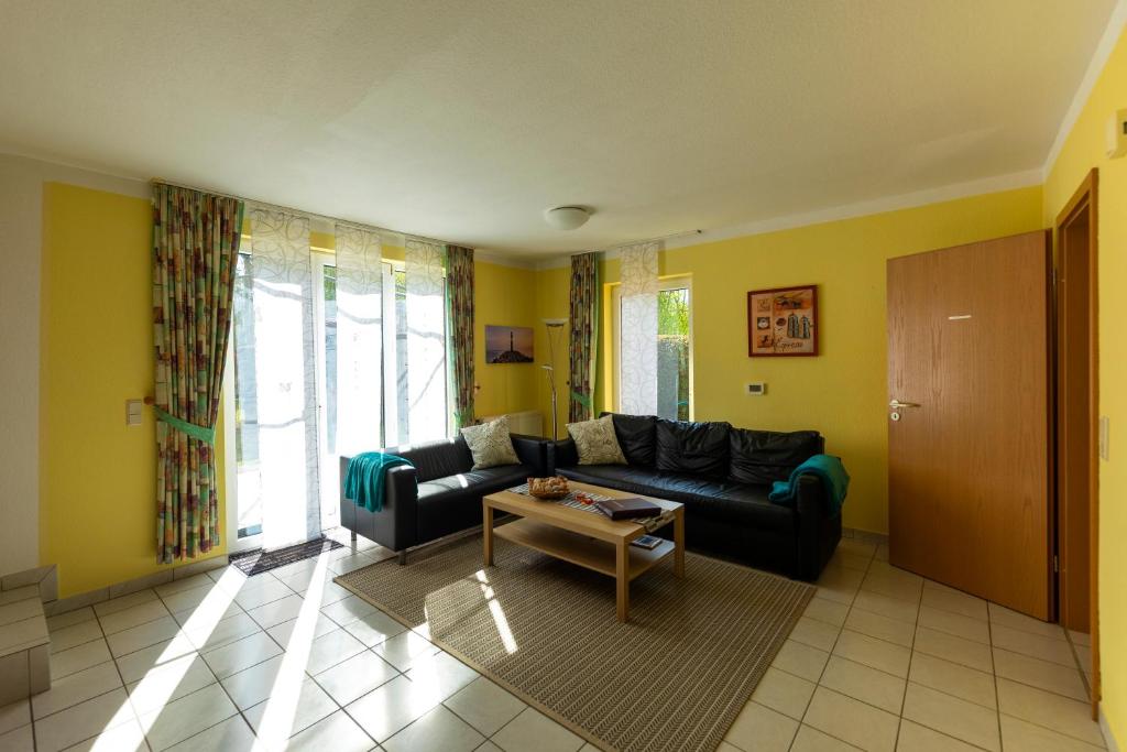 ein Wohnzimmer mit einem Sofa und einem Tisch in der Unterkunft Ferienhaus-Butterblume in Papenburg