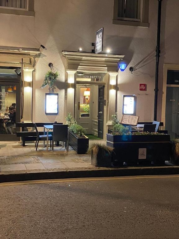 a building with a table outside of it at night at No12 Hotel in North Berwick