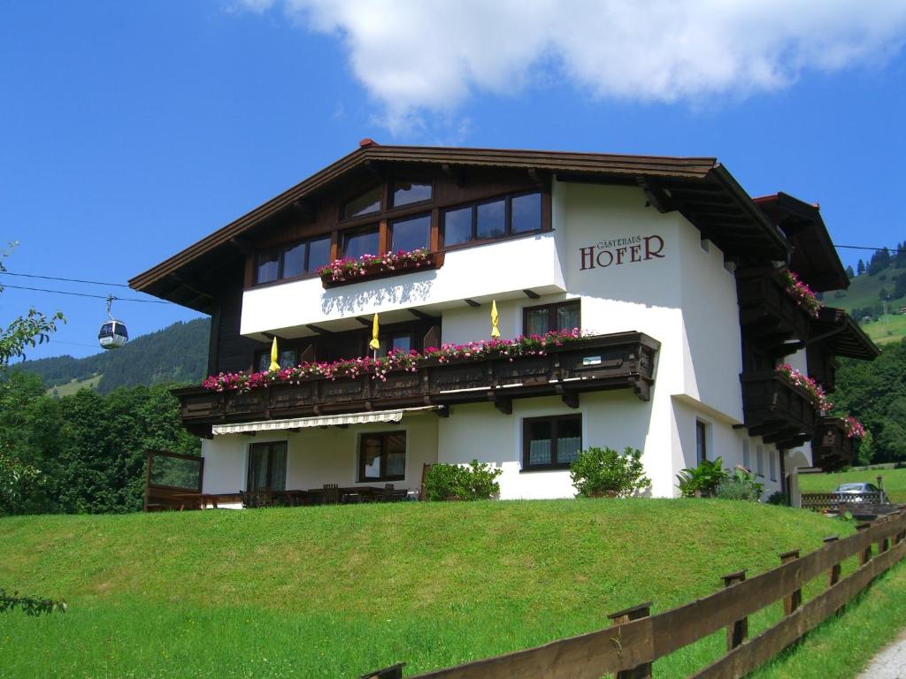 ein großes weißes Gebäude mit Blumen auf dem Balkon in der Unterkunft Gästehaus Hofer in Brixen im Thale