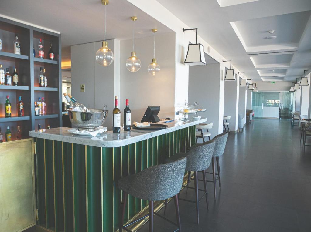 a bar in a restaurant with chairs and bottles of wine at Hotel Baia in Cascais