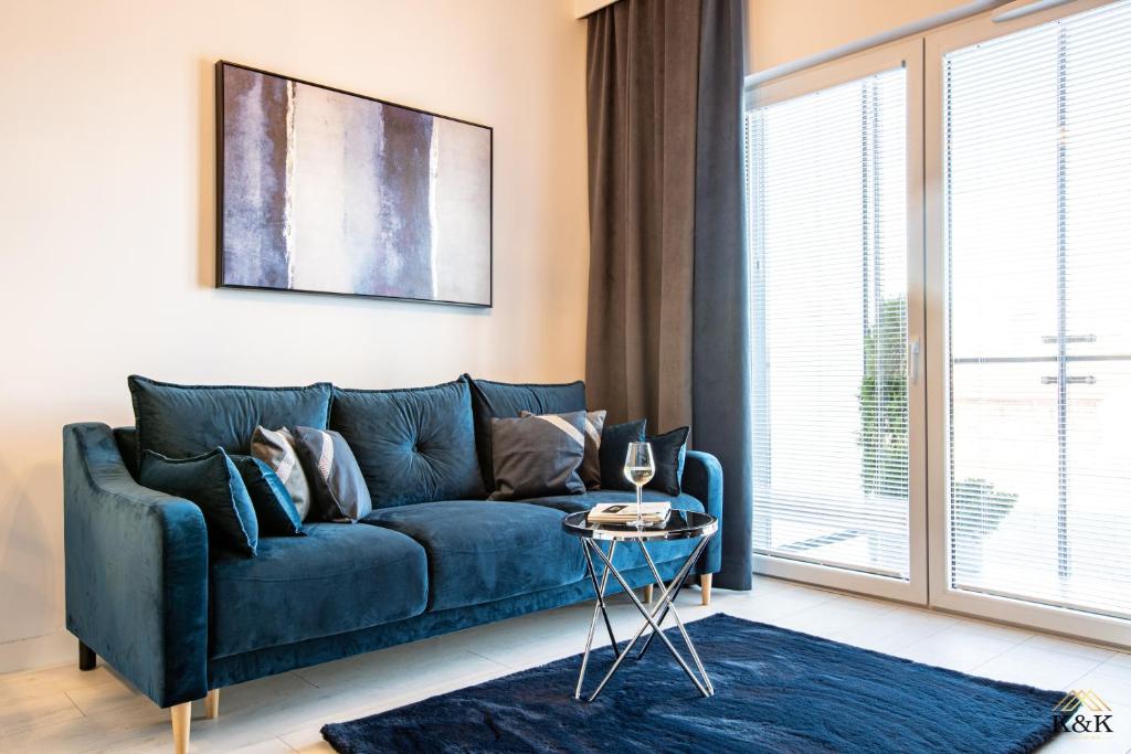 Sofá azul en la sala de estar con ventana en K&K Apartament blisko Centrum Near City Center, en Varsovia