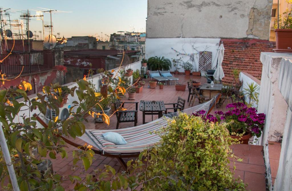 un balcón con hamaca, mesas y sillas en B&B Epoche' en Nápoles