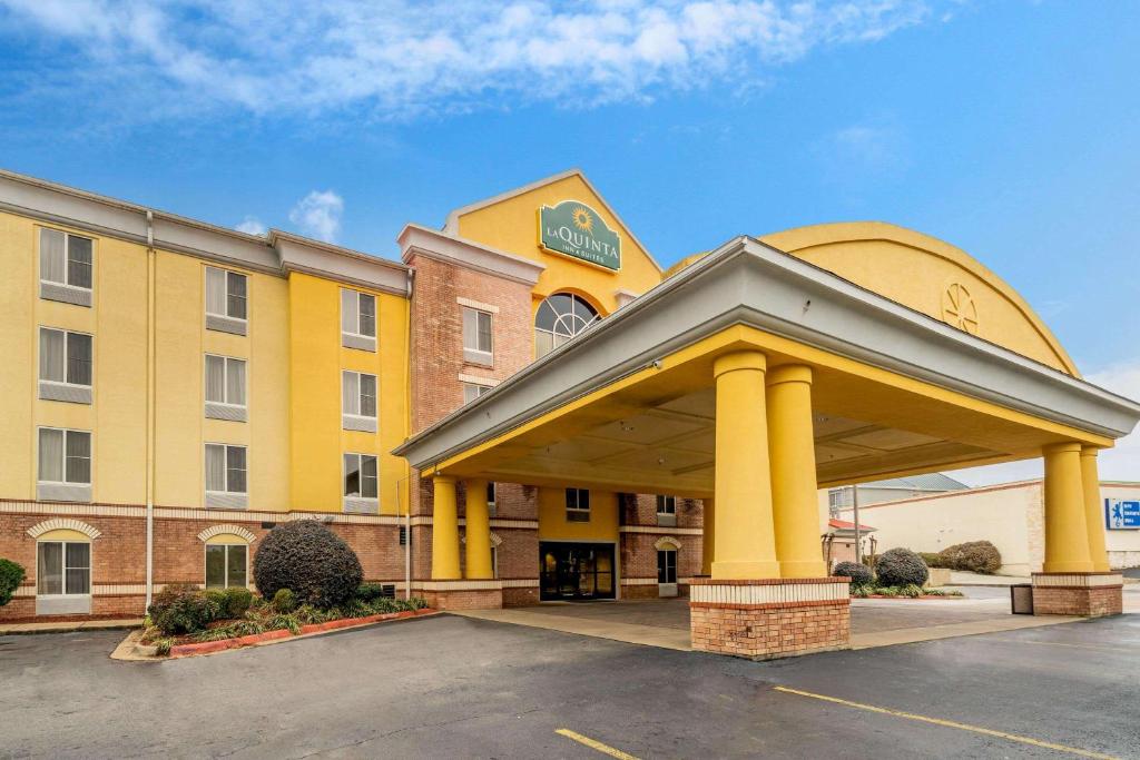 a hotel with a yellow building with a parking lot at La Quinta by Wyndham Hot Springs in Hot Springs