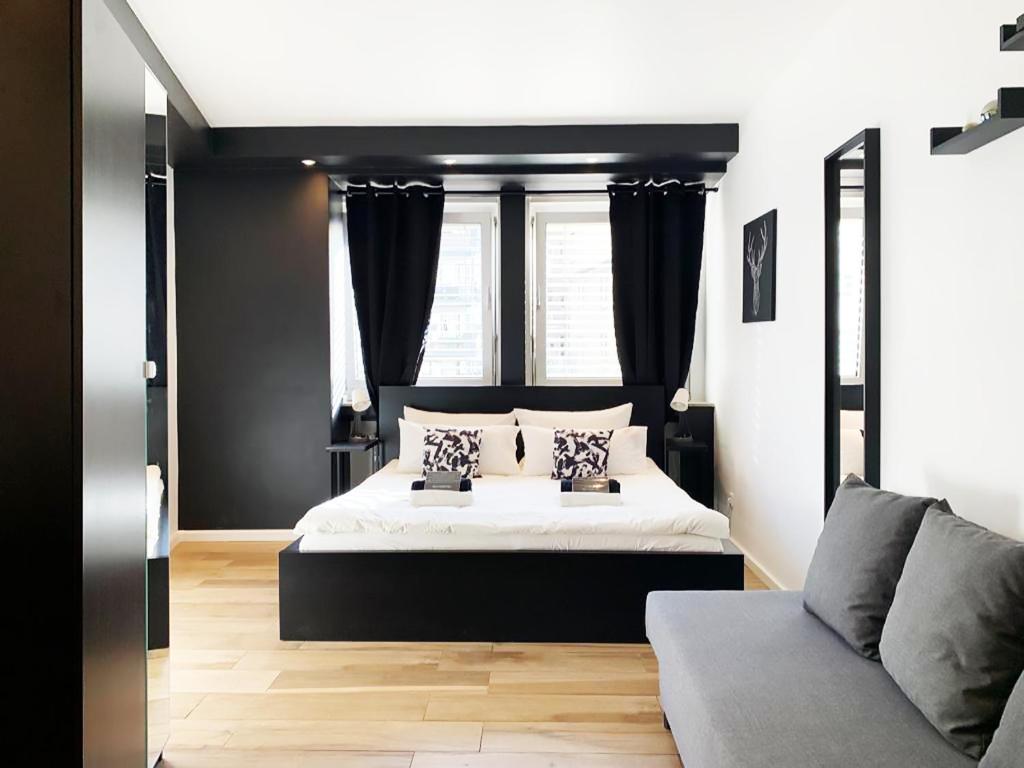 a black and white bedroom with a bed and a couch at BLK Hostel in Düsseldorf