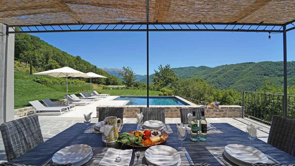 Villa La Braja في Licciana Nardi: طاولة مع طبق من الطعام فوق الفناء