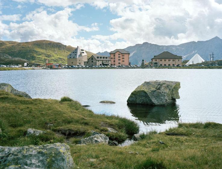 a large rock in the middle of a large lake at Ospizio San Gottardo in Airolo