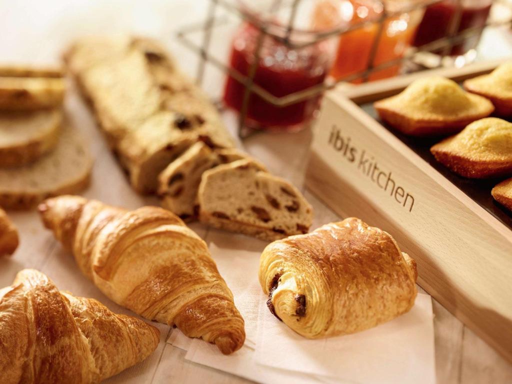 a table with a bunch of different types of bread at ibis Cambrai in Cambrai