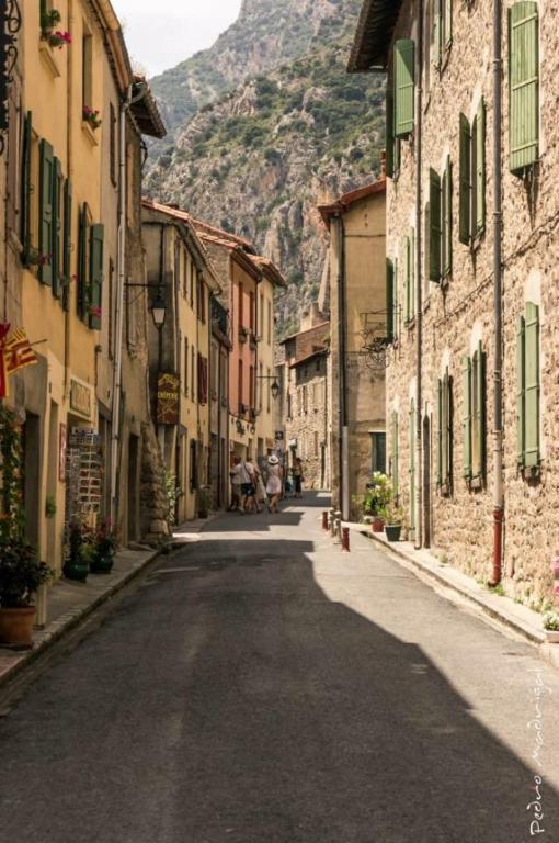 Une rue vide avec des bâtiments et une montagne en arrière-plan dans l'établissement Maison les Ramparts, à Villefranche-de-Conflent