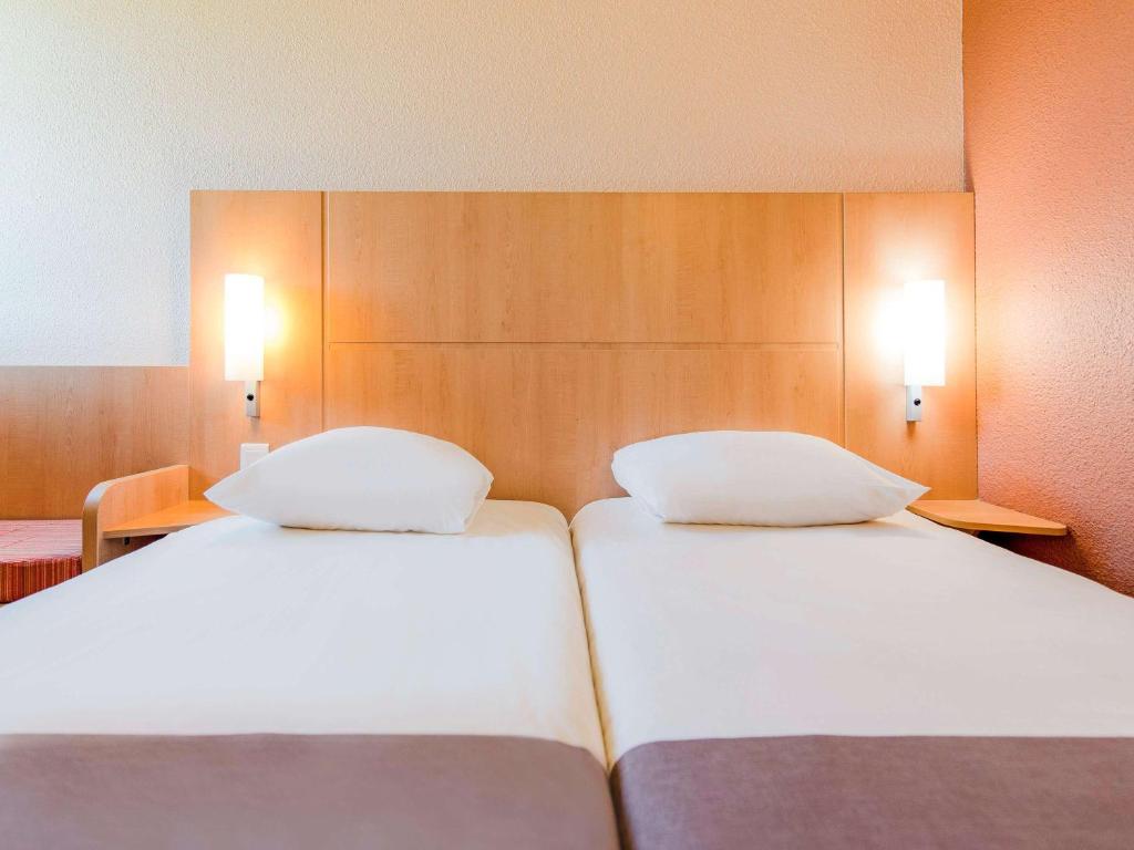 Postel nebo postele na pokoji v ubytování ibis Besançon Marchaux