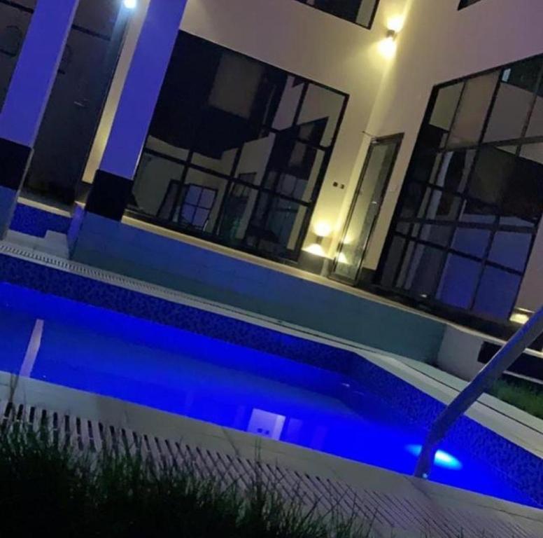 una casa con piscina por la noche en فيلا بلاتنيوم اند كي ام, en Unaizah