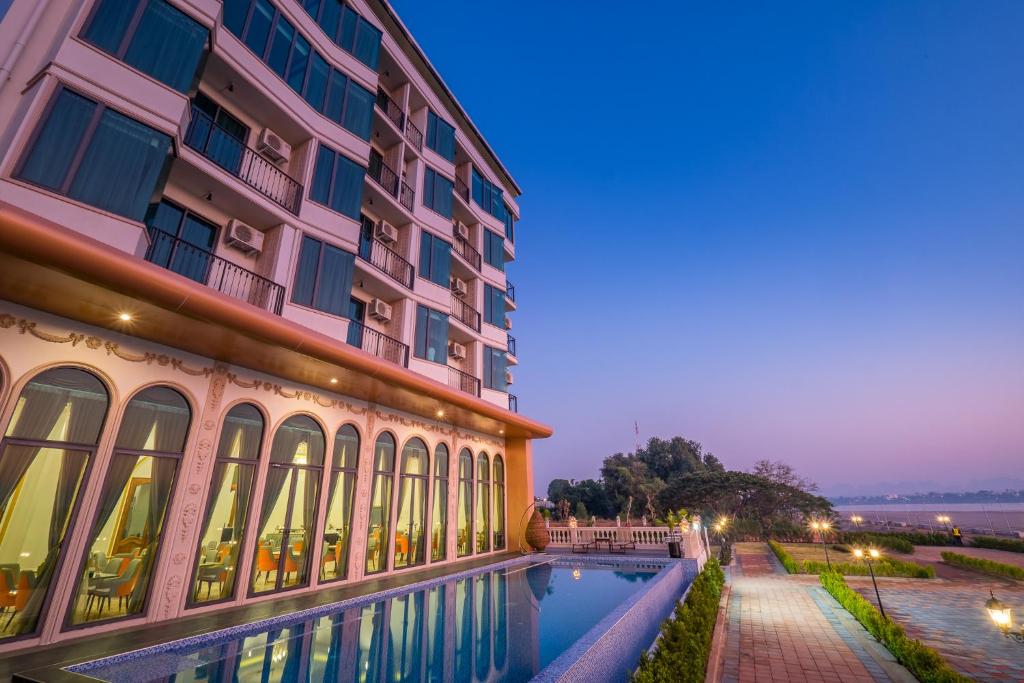 un hotel con piscina frente a un edificio en Mekong Heritage Hotel en Nakhon Phanom