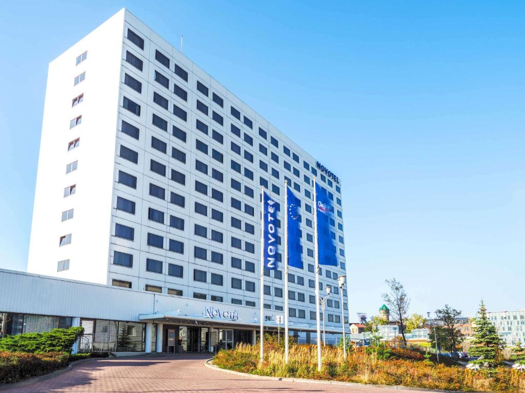 Ein weißes Gebäude mit einem Schild drauf. in der Unterkunft Novotel Katowice Centrum in Kattowitz