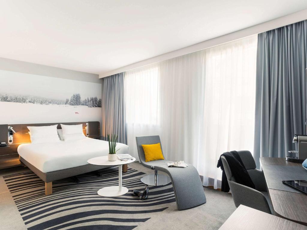 a hotel room with a bed and a desk at Novotel Paris Centre Gare Montparnasse in Paris