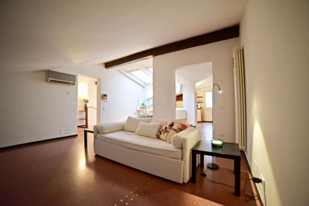 Una sala de estar con un sofá blanco y una mesa. en Casa Mosaico, en Vicenza