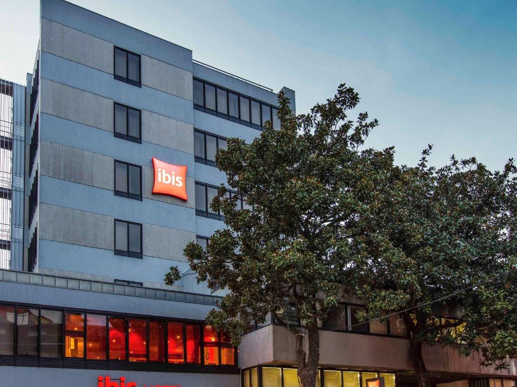 Un edificio grande con un cartel de autobús. en ibis Porto Centro São Bento, en Oporto