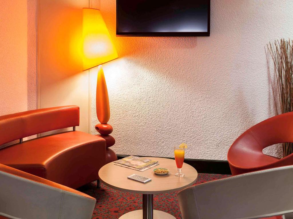 ein Hotelzimmer mit einem Tisch, Stühlen und einer Lampe in der Unterkunft ibis Auch in Auch