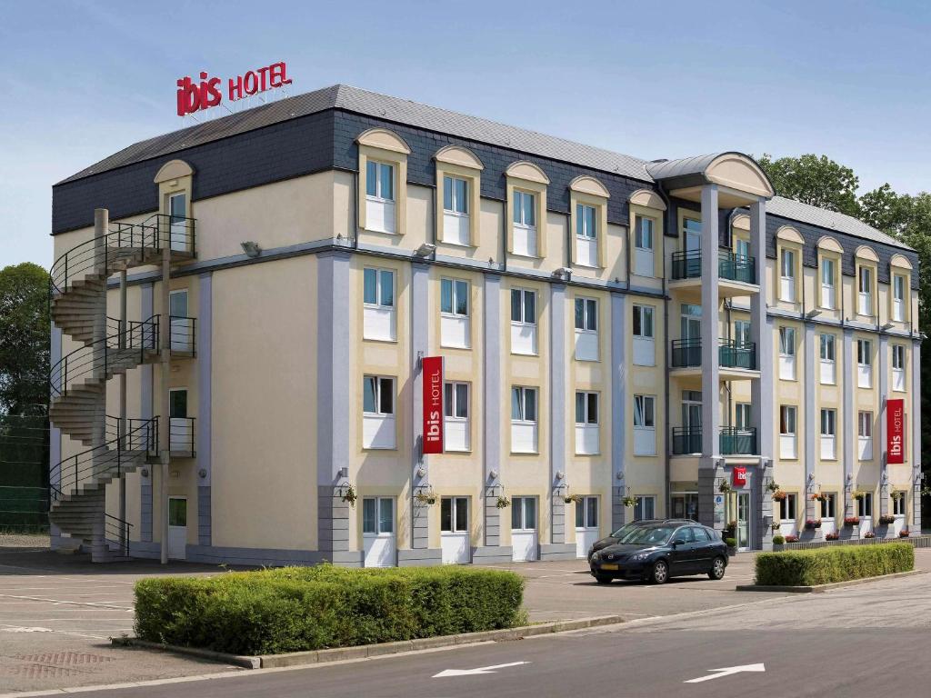 a large white building with a sign on it at ibis Liège Seraing in Boncelles
