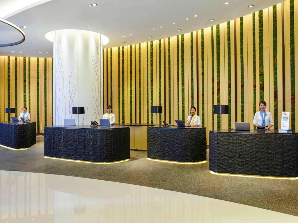 a group of people sitting at desks in a lobby at Novotel Century Hong Kong in Hong Kong