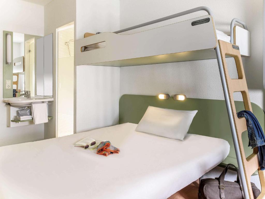 a small room with a bunk bed with a ladder at ibis budget Berlin Alexanderplatz in Berlin