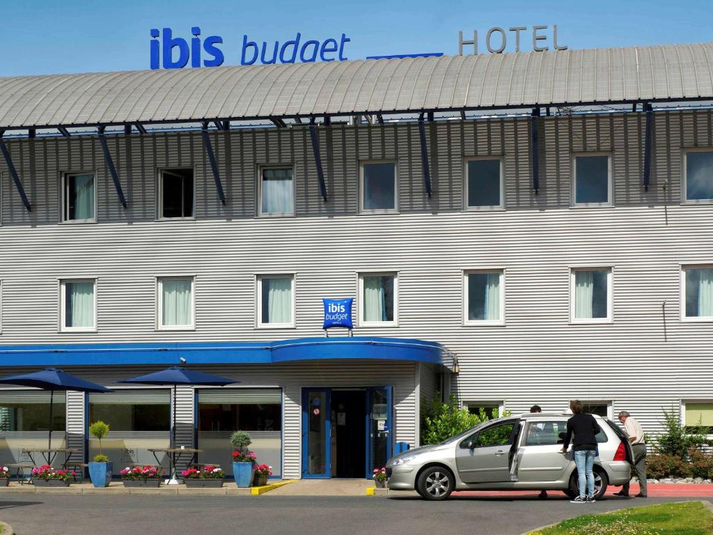 un hôtel avec une voiture garée devant lui dans l'établissement ibis Budget Charleroi Airport, à Charleroi