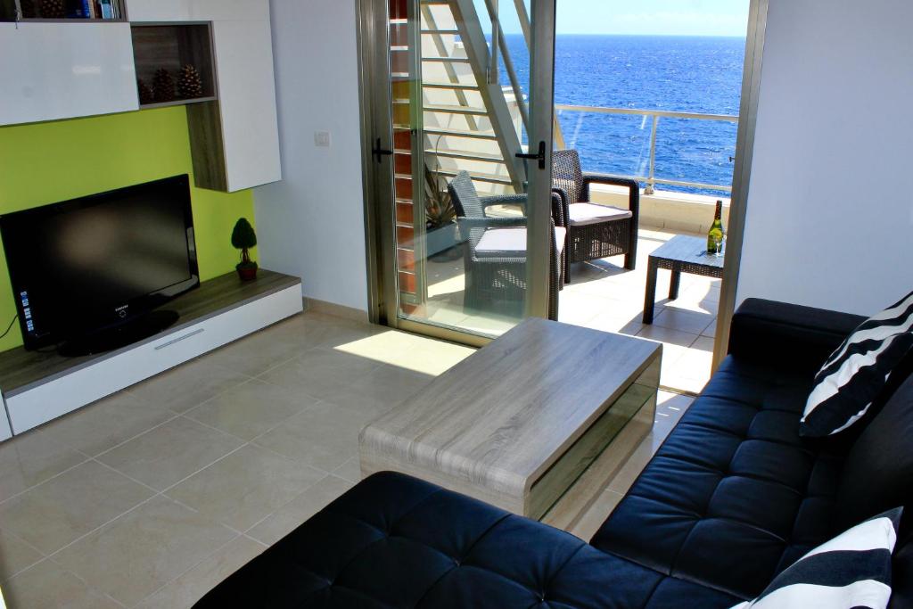 a living room with a couch and a television at Ocean View Apartment in Poris de Abona
