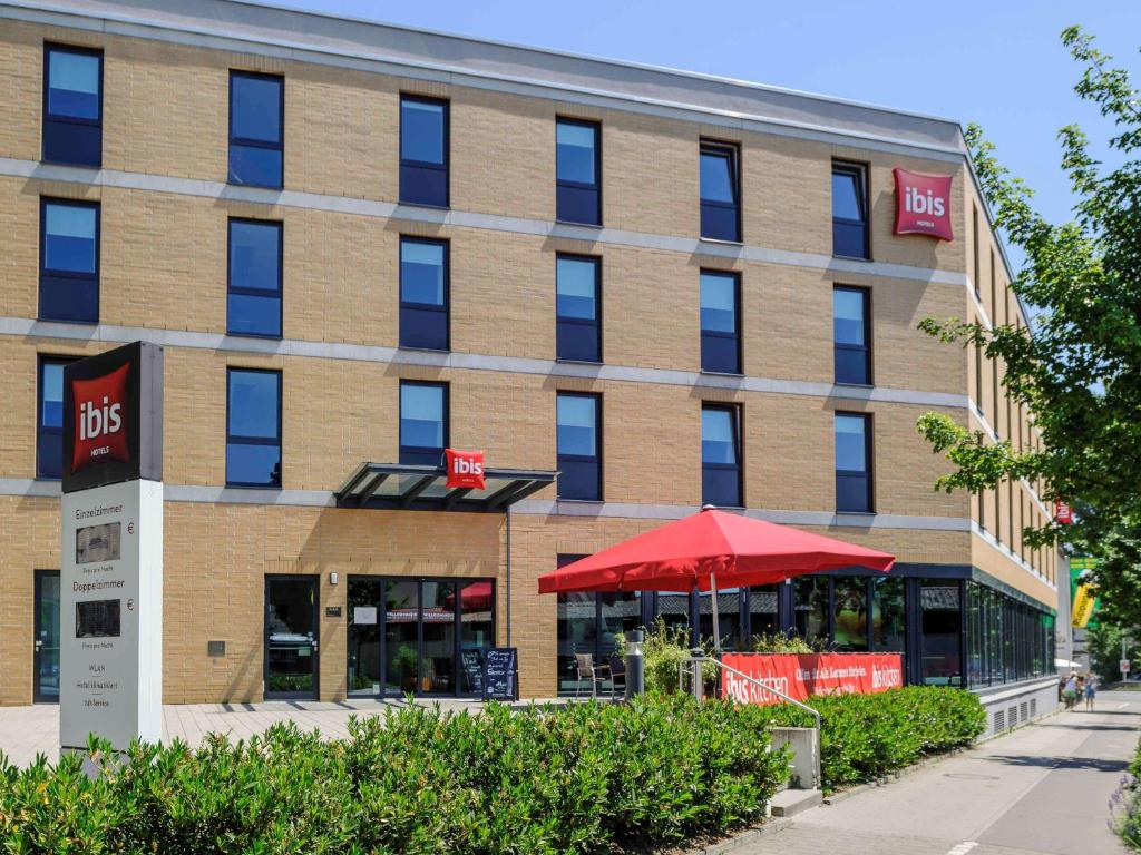 a brick building with a red umbrella in front of it at ibis Konstanz in Konstanz