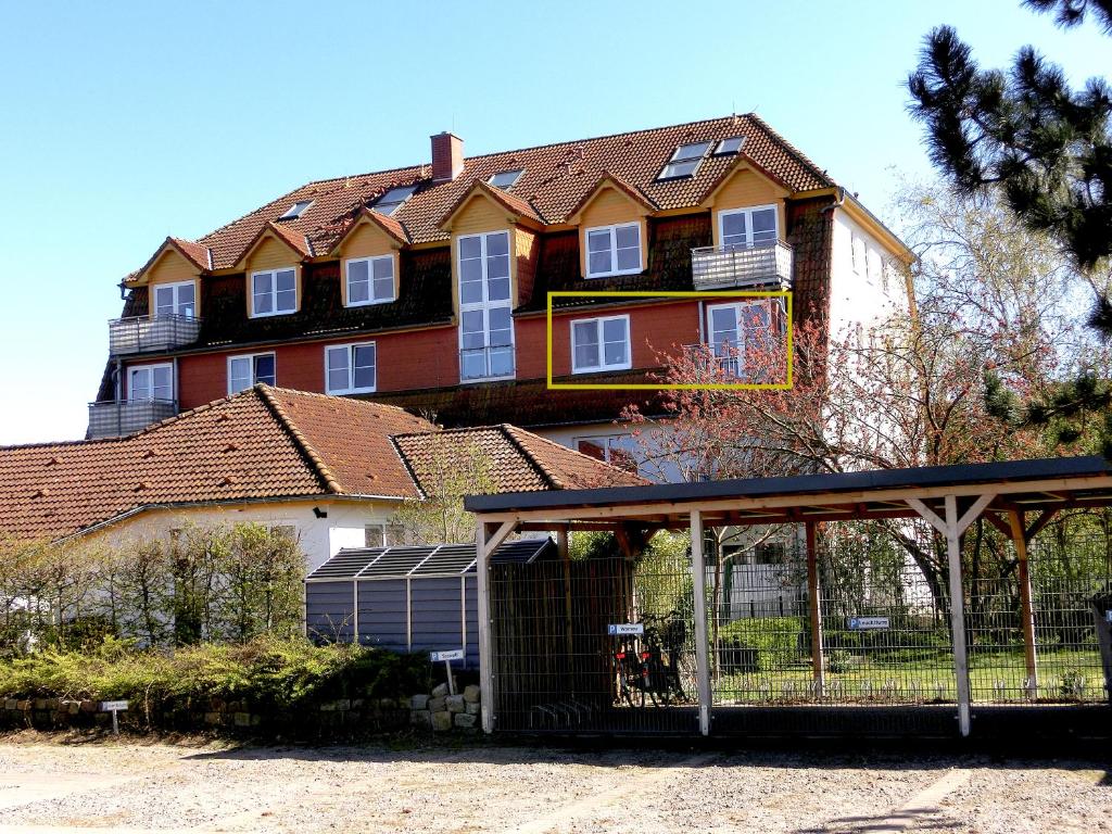 ein großes Haus mit einem Zaun davor in der Unterkunft Fewo Neptun im Landhaus Immenbarg in Rostock