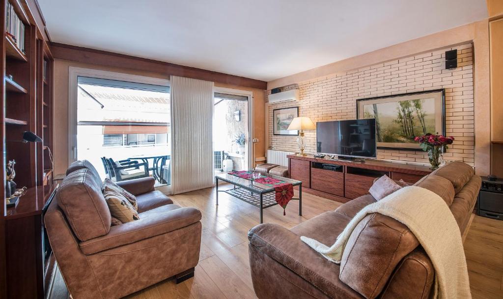 uma sala de estar com dois sofás e uma televisão em Apartment Montserrat 11-1 em Calafell