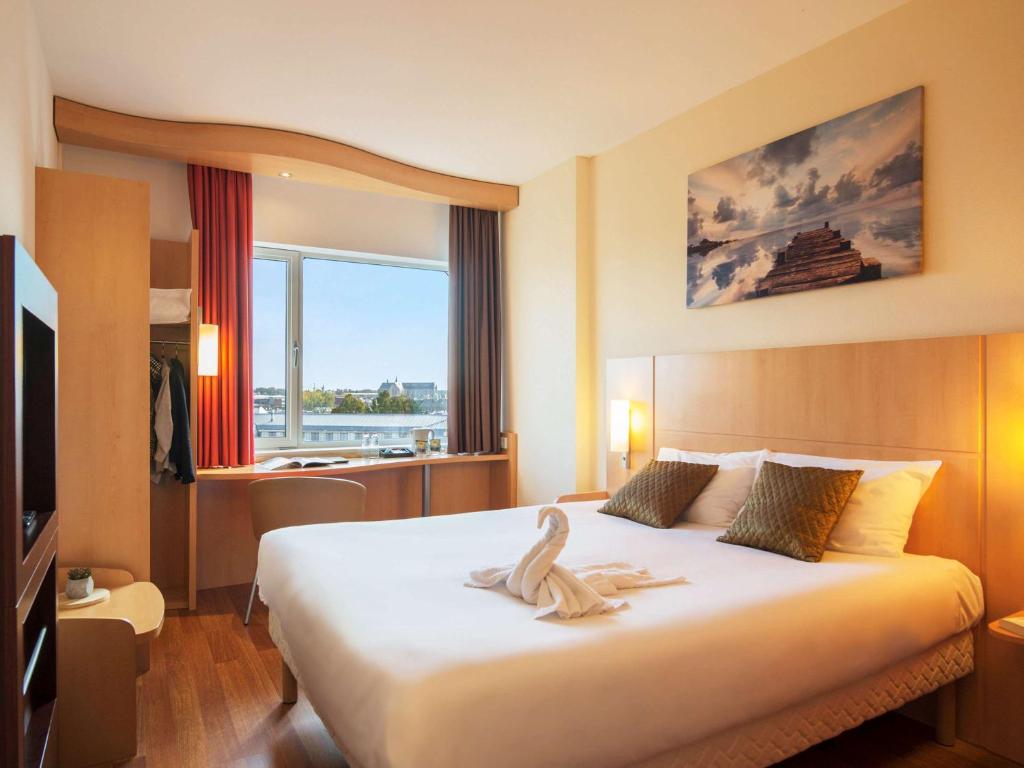 een hotelkamer met een bed met een handdoek erop bij ibis Leiden Centre in Leiden