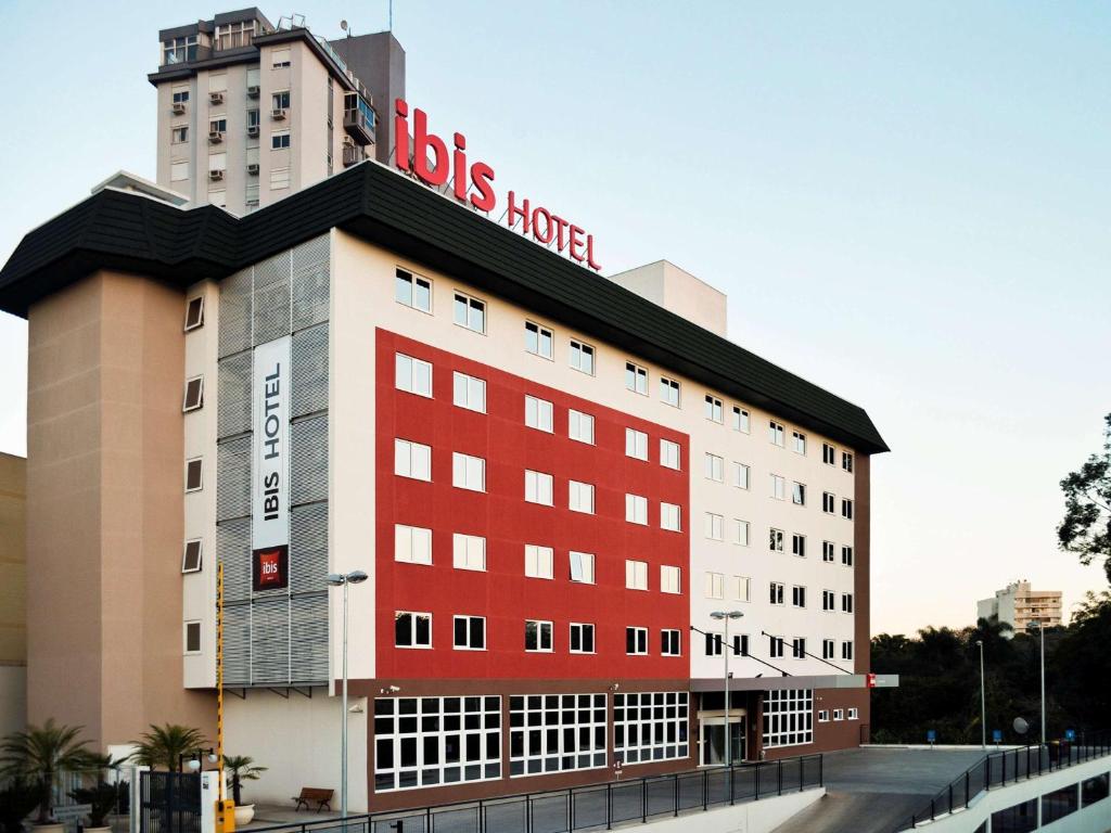 a large red building with a bus hotel on top at ibis Novo Hamburgo in Novo Hamburgo