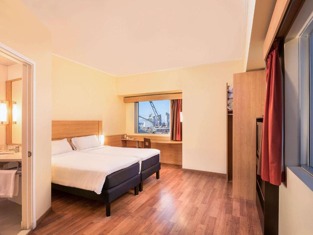 a hotel room with a bed and a window at ibis Valparaiso in Valparaíso