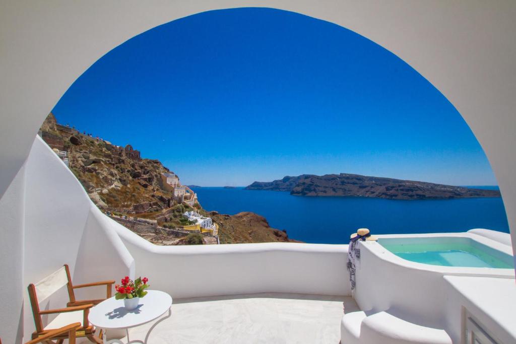 Cette chambre dispose d'une baignoire et offre une vue sur l'océan. dans l'établissement Oia Mare Villas, à Oia