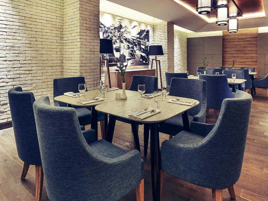 a dining room with tables and chairs with wine glasses at Mercure Jakarta Sabang in Jakarta