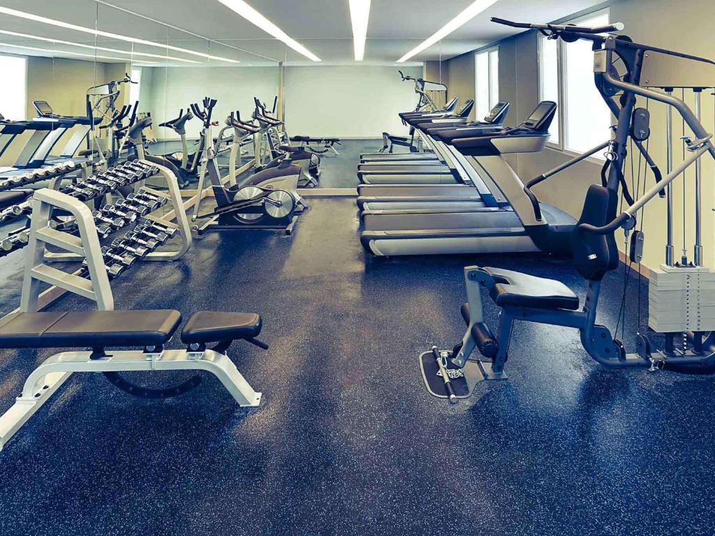 a gym with rows of treadmills and machines at Mercure Jakarta Sabang in Jakarta