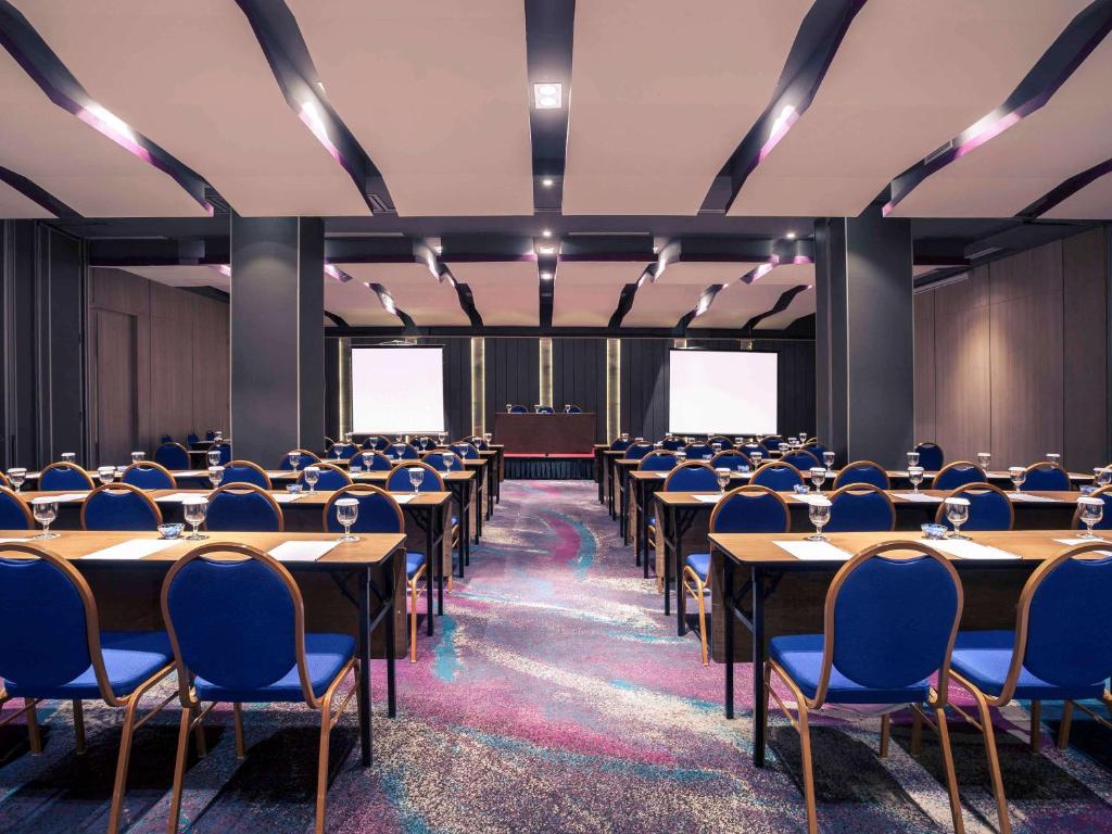 a conference room with tables and chairs and a podium at Mercure Jakarta Sabang in Jakarta