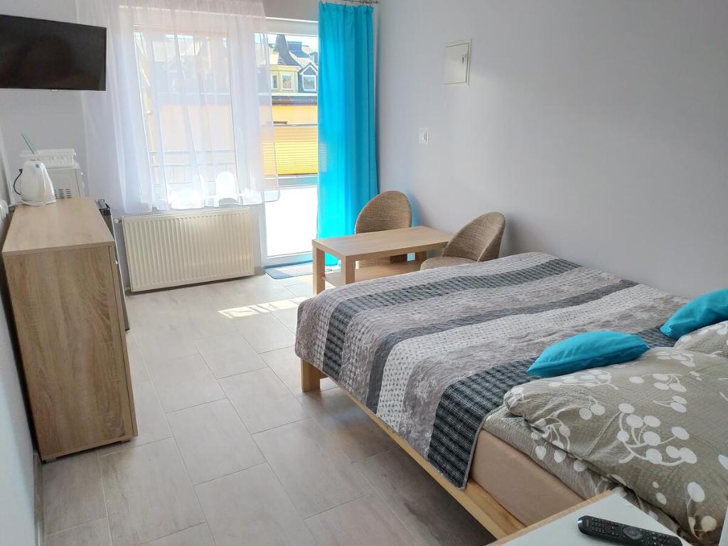 Moris 2 Pokoje Gościnne في ليبا: غرفة نوم بسرير وطاولة ونافذة