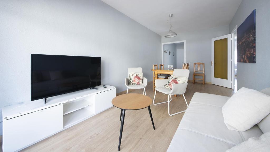 un salon avec une grande télévision à écran plat dans l'établissement R68 Apartamento Montserrat 32-3, à Calafell